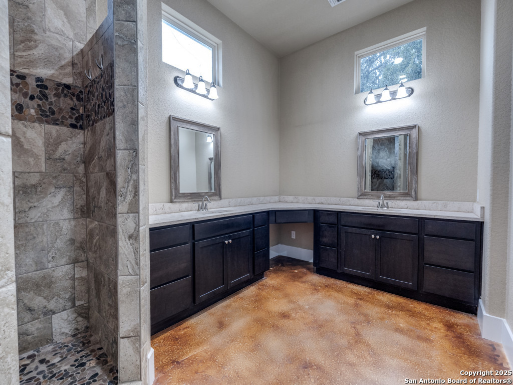 629 Windmill Ranch Road Spring Branch, TX 78070 - Photo 20 of 34 a bathroom with a granite countertop sink a mirror and a vanity