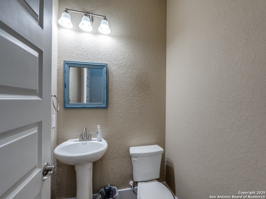 629 Windmill Ranch Road Spring Branch, TX 78070 - Photo 26 of 34 a bathroom with a toilet sink and mirror