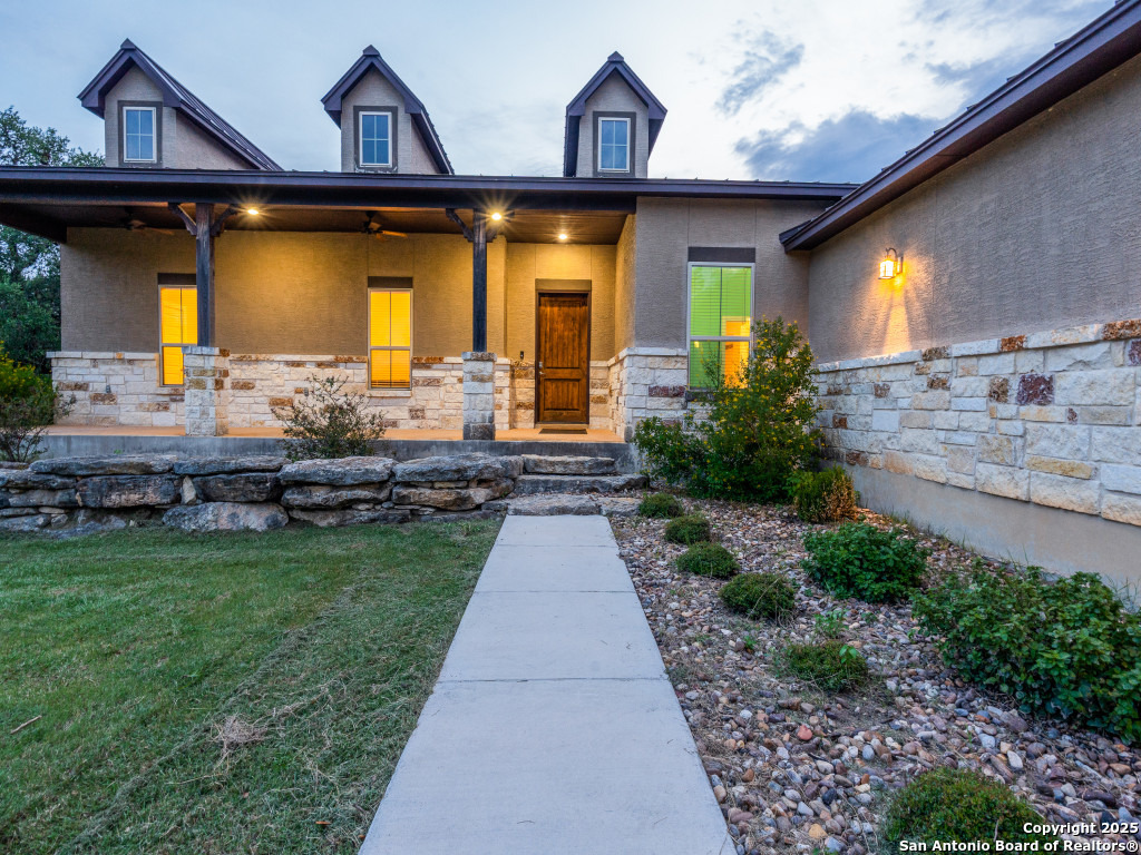 629 Windmill Ranch Road Spring Branch, TX 78070 - Photo 4 of 34 a front view of a house with garden