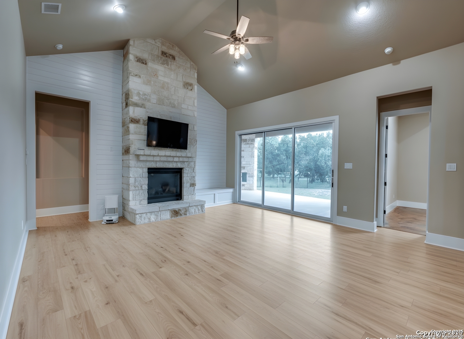 629 Windmill Ranch Road Spring Branch, TX 78070 - Photo 5 of 34 an empty room with wooden floor fireplace and windows