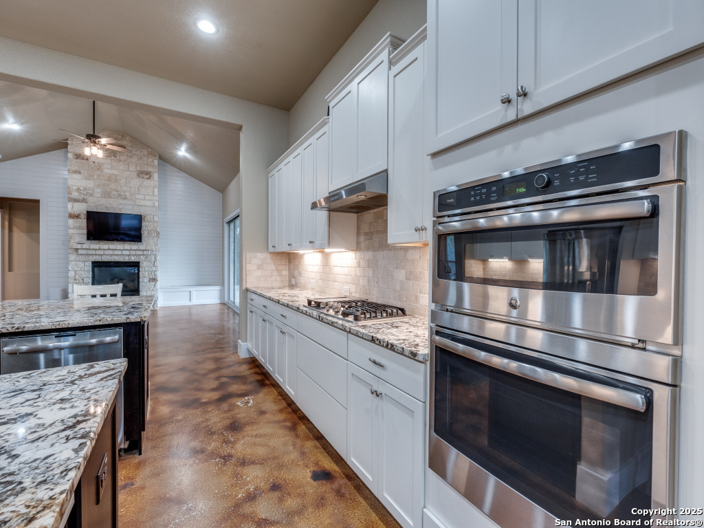 629 Windmill Ranch Road Spring Branch, TX 78070 - Photo 10 of 34 a kitchen with stainless steel appliances kitchen island granite countertop a stove a sink and a microwave