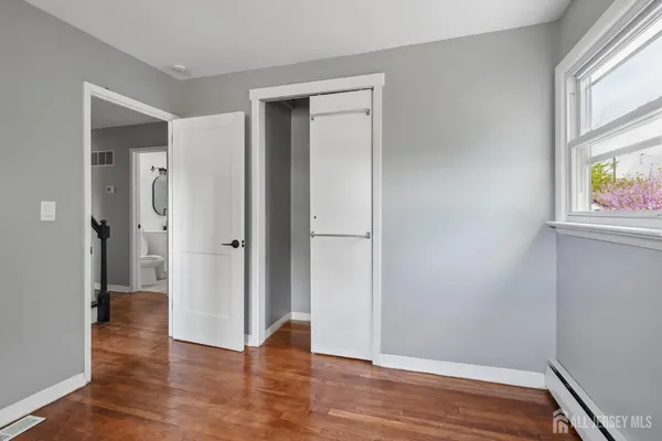 an empty room with wooden floor and a window