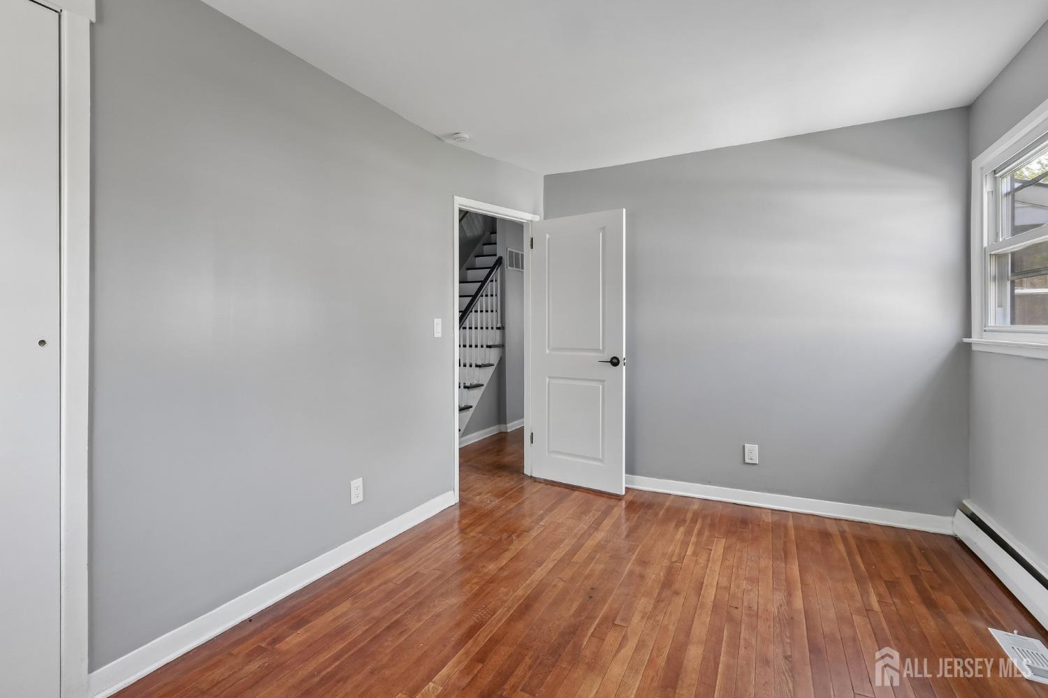 2 Westbury Road Iselin, NJ 08830 - Photo 13 of 25 an empty room with wooden floor and windows