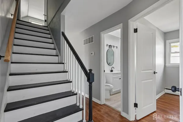 a view of a hallway with wooden floor and staircase