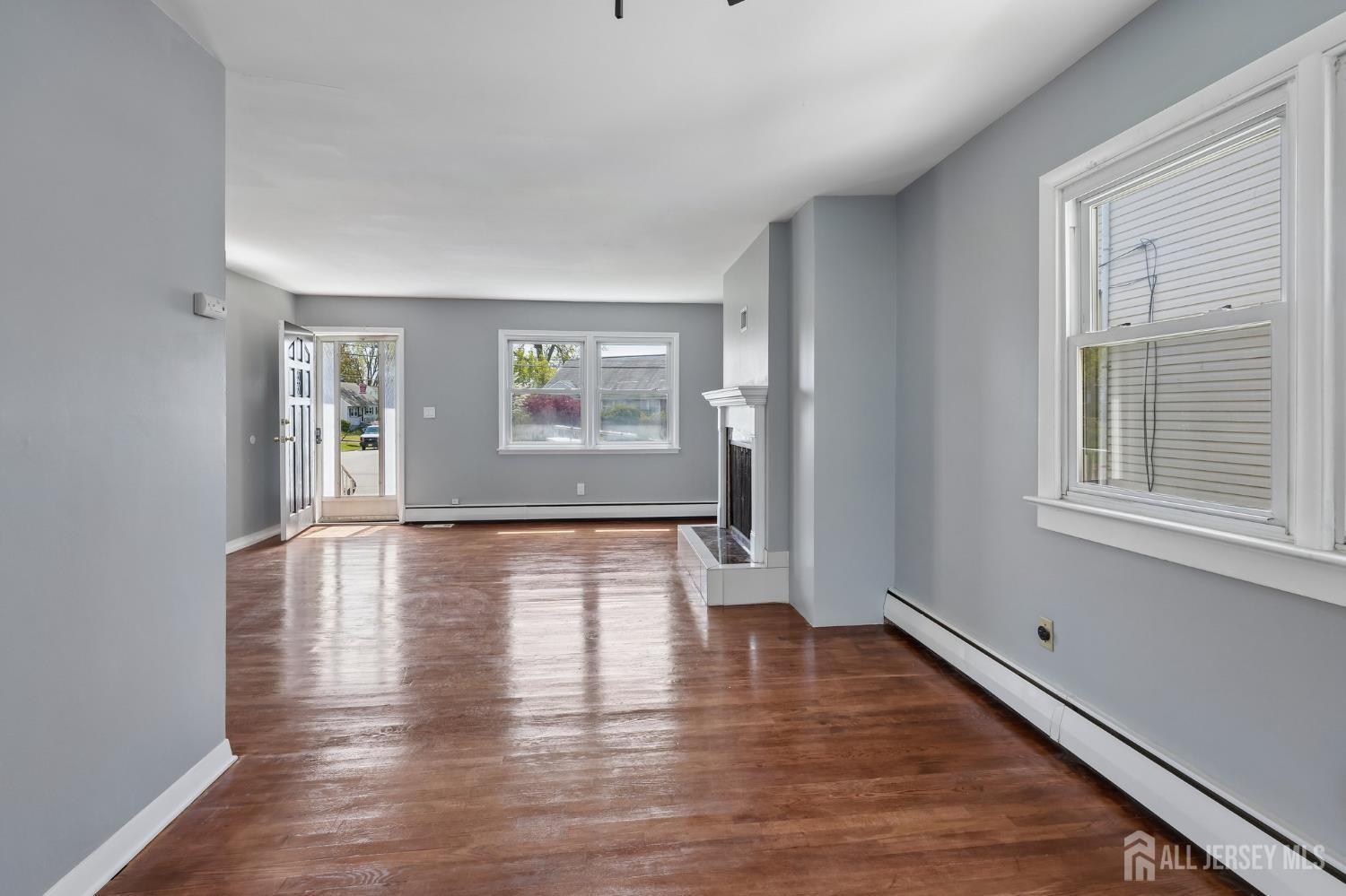 2 Westbury Road Iselin, NJ 08830 - Photo 6 of 25 a view of an empty room with wooden floor and a window