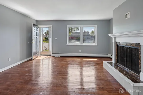 wooden floor fireplace and windows in an empty room