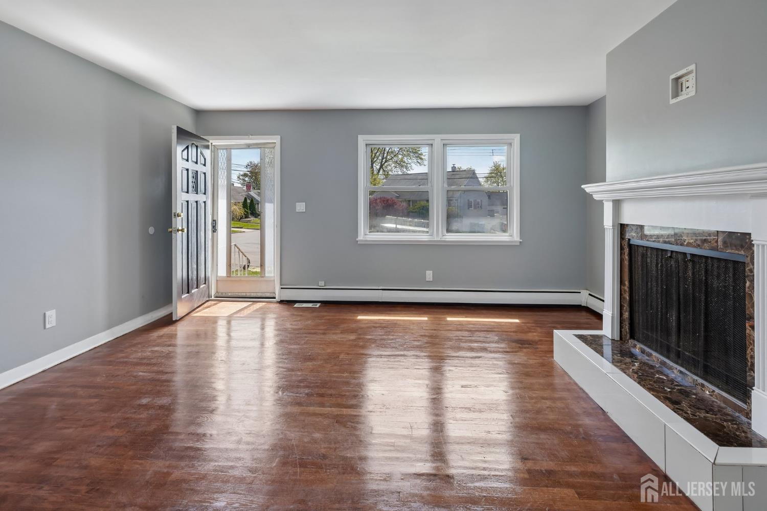 2 Westbury Road Iselin, NJ 08830 - Photo 7 of 25 wooden floor fireplace and windows in an empty room
