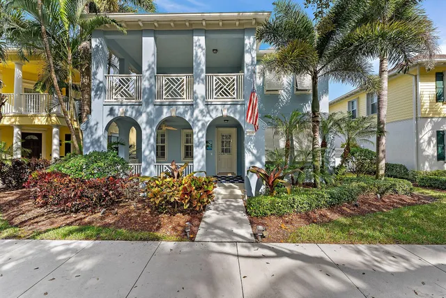 a front view of multi story residential apartment building with yard and green space