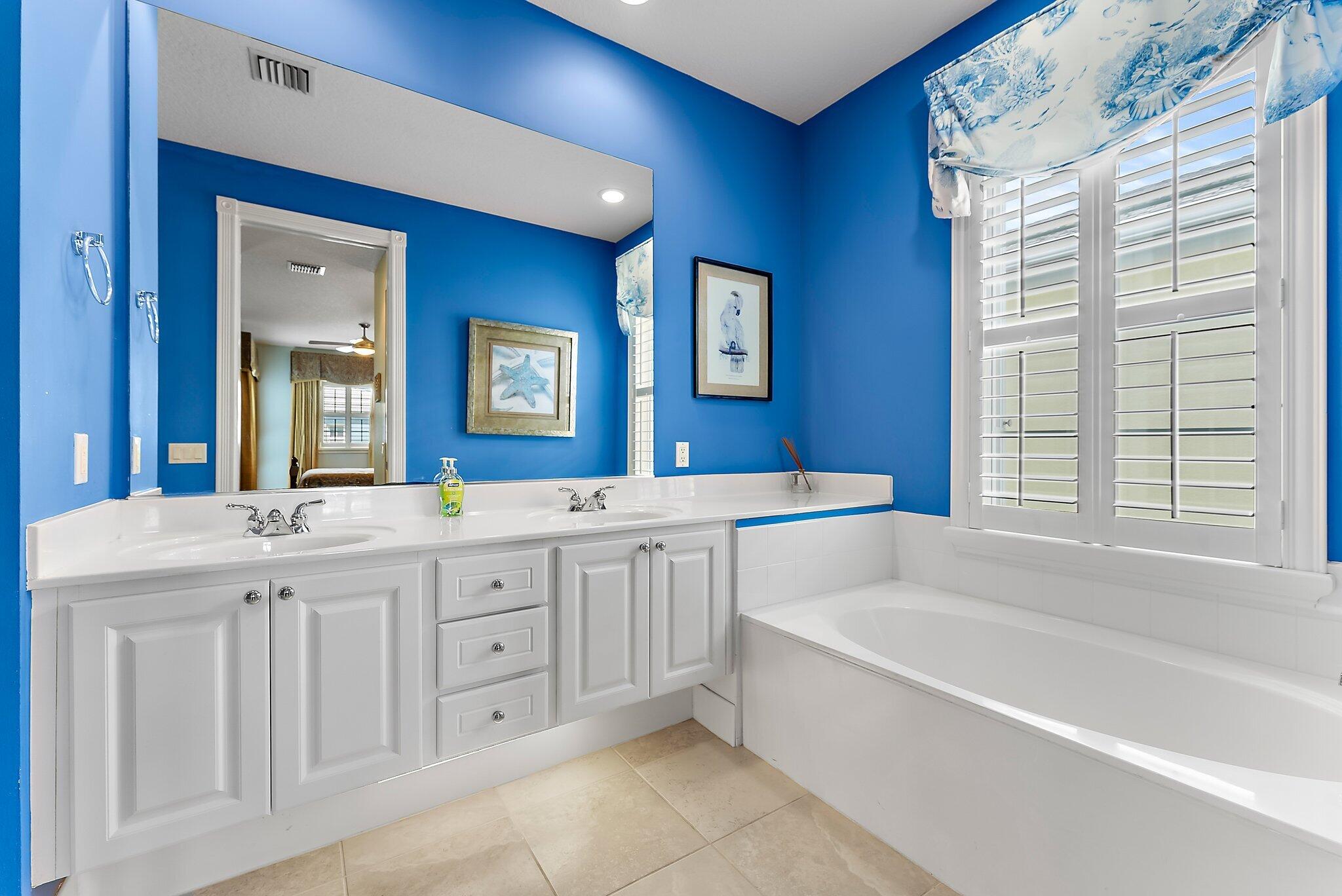 115 Castries Drive Jupiter, FL 33458 - Photo 29 of 60 a spacious bathroom with a double vanity sink a large mirror a bathtub and next to a window