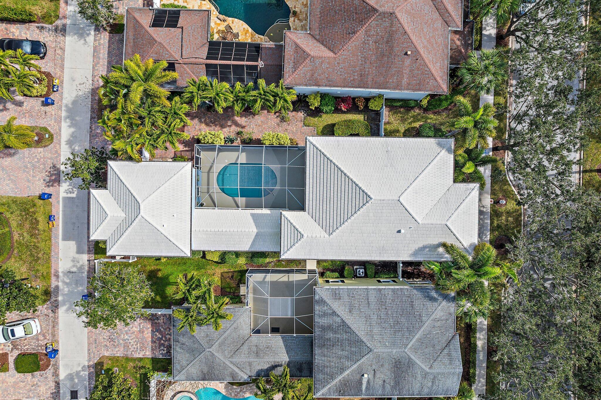 115 Castries Drive Jupiter, FL 33458 - Photo 53 of 60 an aerial view of a house with a garden and a wooden bench