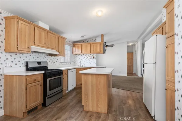 a kitchen with stainless steel appliances granite countertop a stove a sink dishwasher and a refrigerator