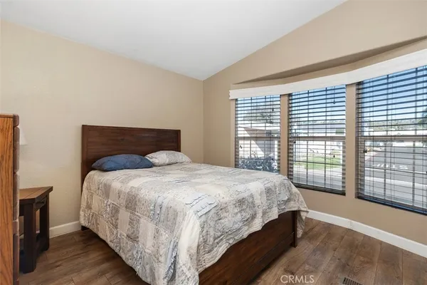a large bed sitting in a bedroom next to a window