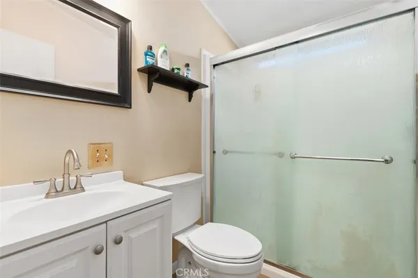 a bathroom with a sink a toilet a shower and a mirror