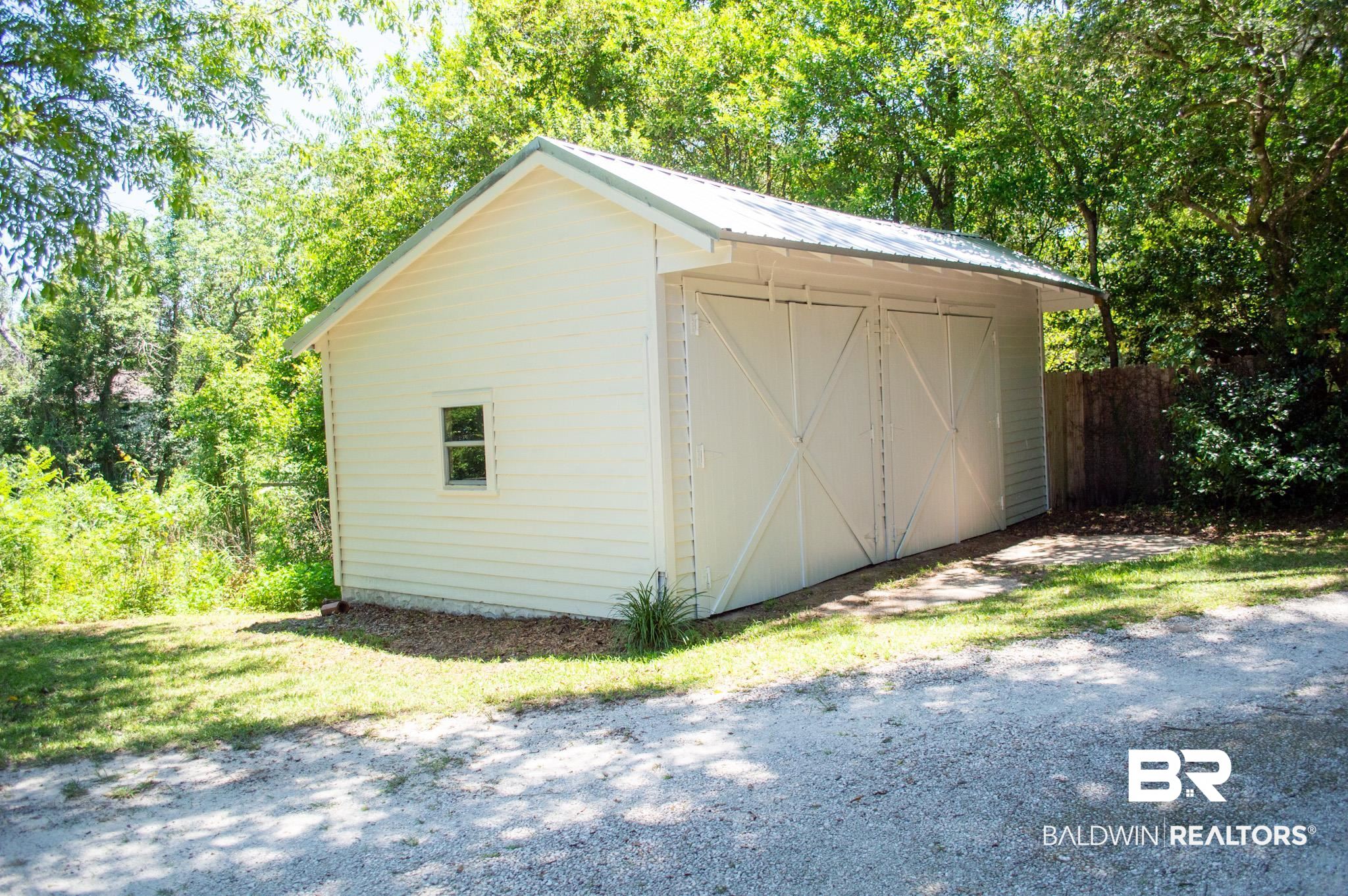18711 Keller Road Foley, AL 36535 - Photo 34 of 38 Detached outbuilding featuring white horizontal siding, a metal roof, and two large barn-style doors