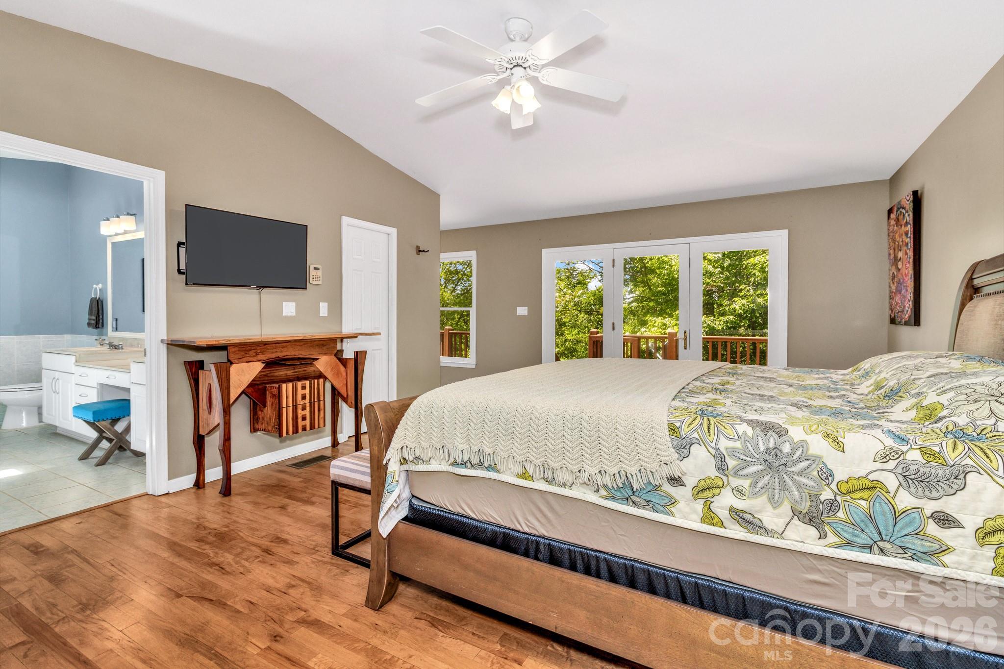 125 Winding Ridge Road Asheville, NC 28803 - Photo 22 of 48 a bed sitting in a bedroom next to a window with a flat screen tv