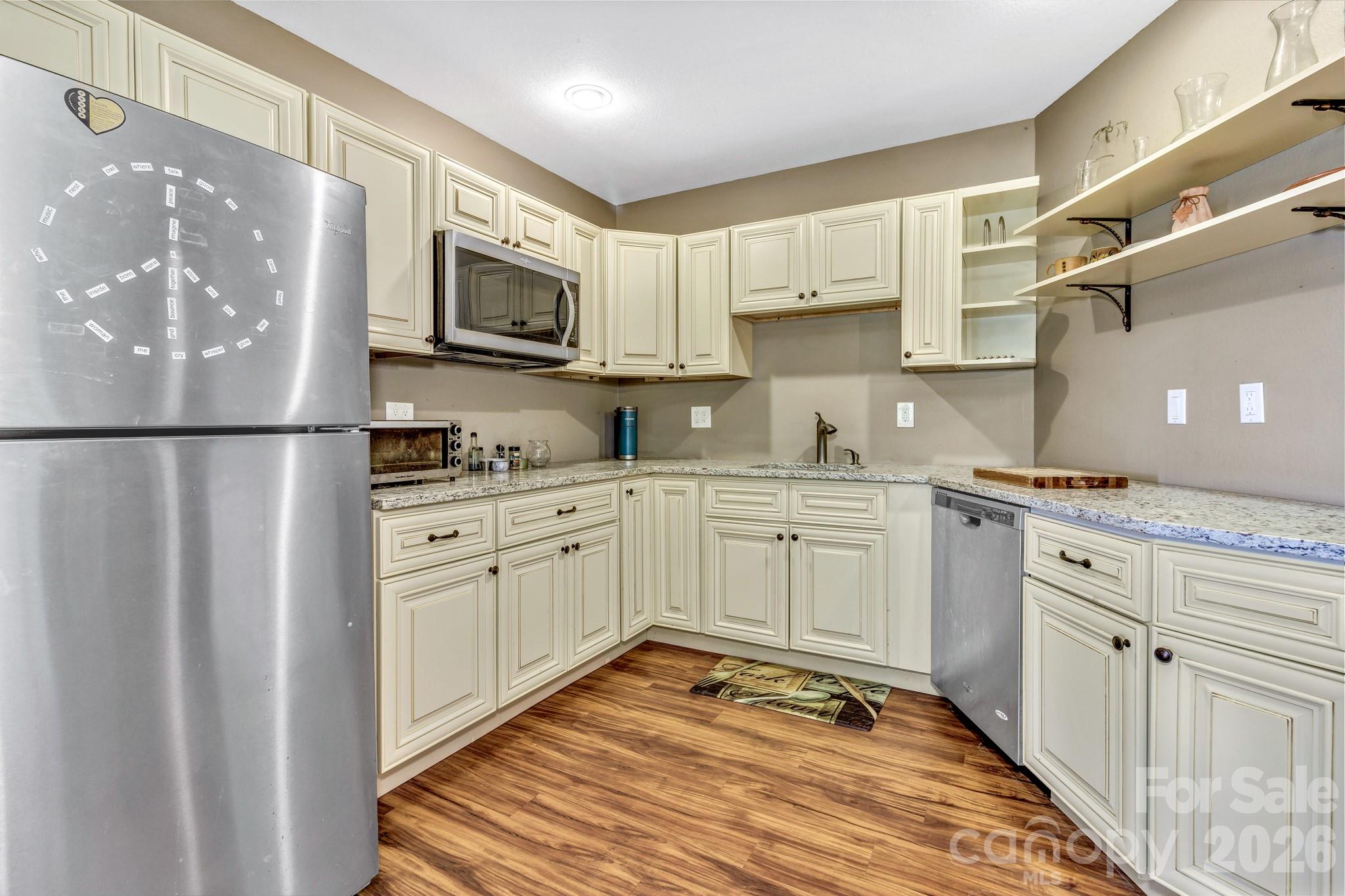 125 Winding Ridge Road Asheville, NC 28803 - Photo 34 of 48 a kitchen with white cabinets and stainless steel appliances