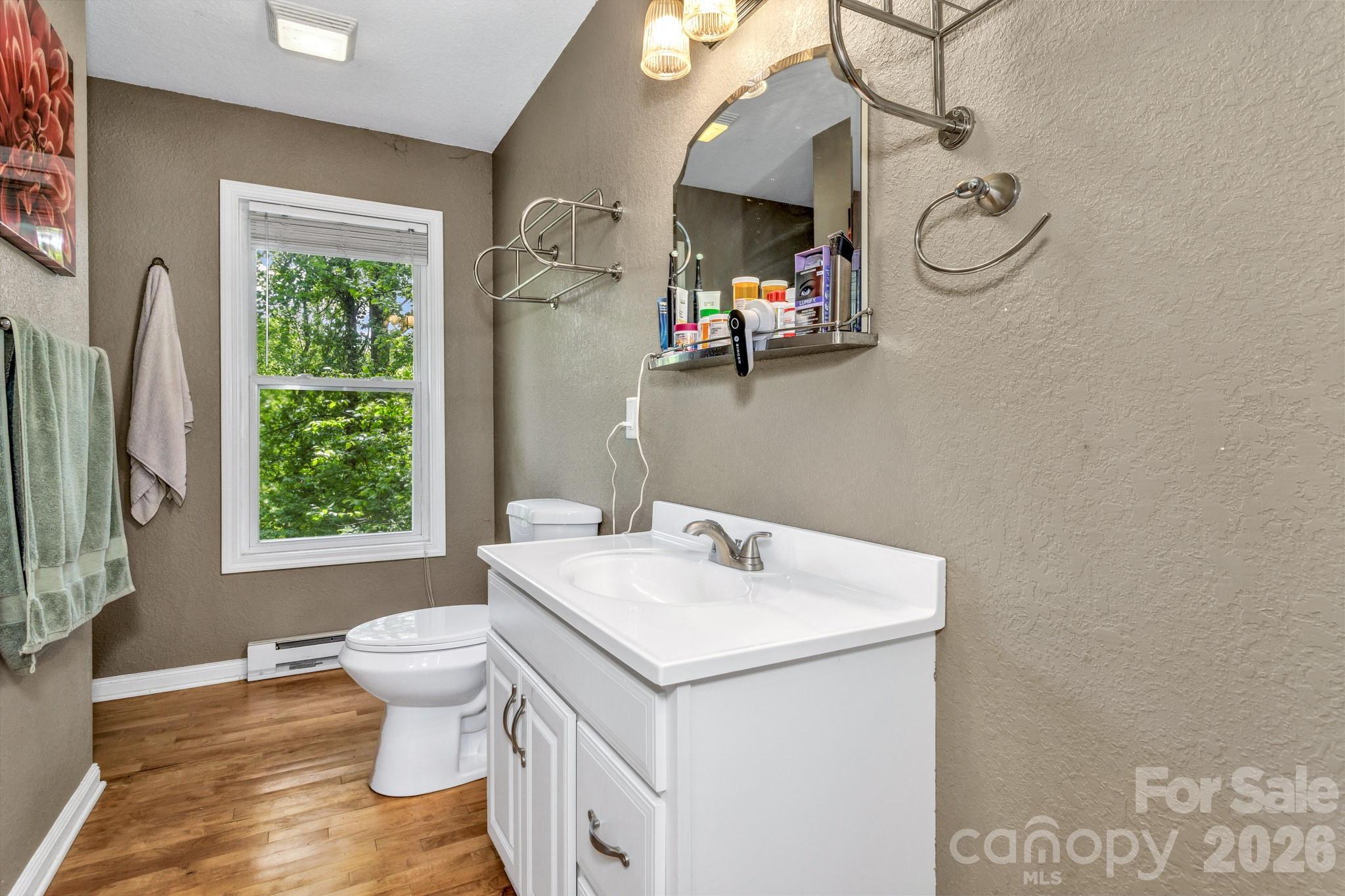 125 Winding Ridge Road Asheville, NC 28803 - Photo 46 of 48 a bathroom with a sink toilet and a window