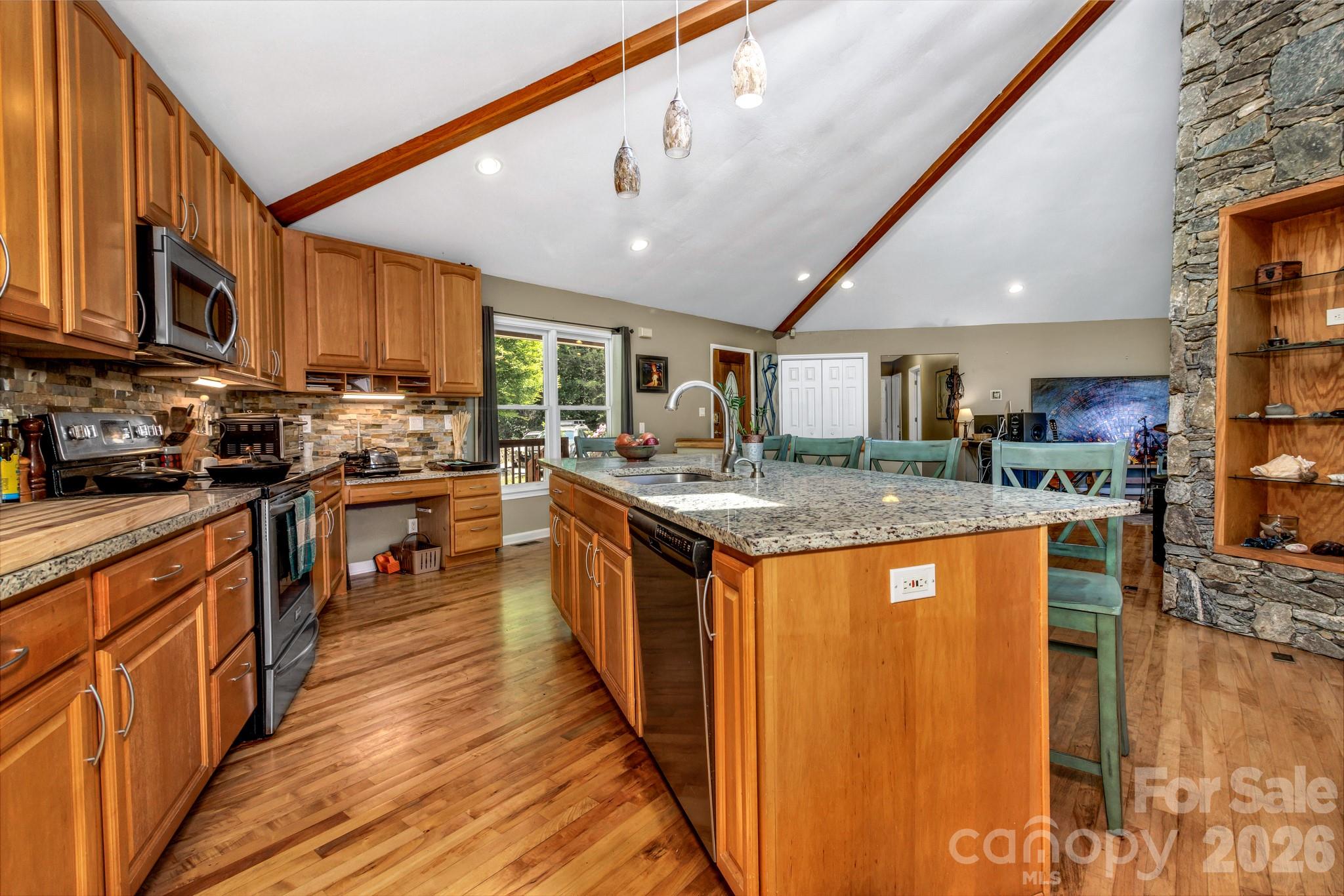 125 Winding Ridge Road Asheville, NC 28803 - Photo 9 of 48 a kitchen with stainless steel appliances granite countertop a stove top oven a sink dishwasher a dining table and chairs with wooden floor