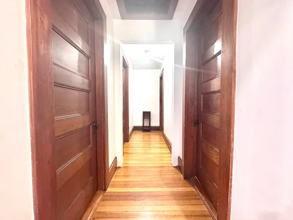 a view of a hallway with wooden floor