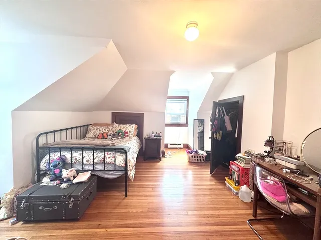 a bedroom with furniture and wooden floor
