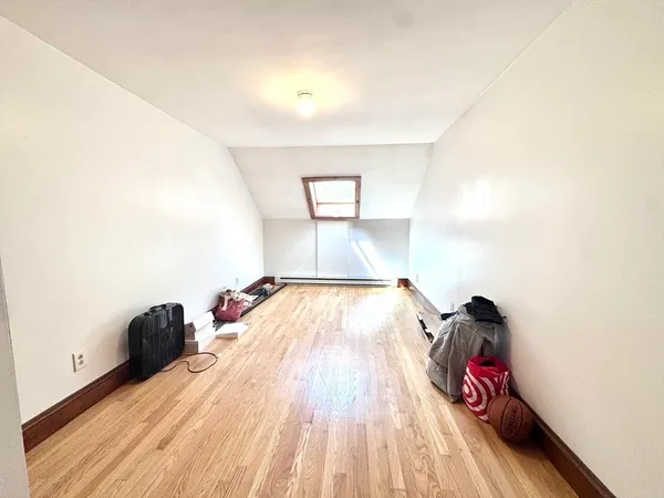 a view of a bedroom with wooden floor and bed