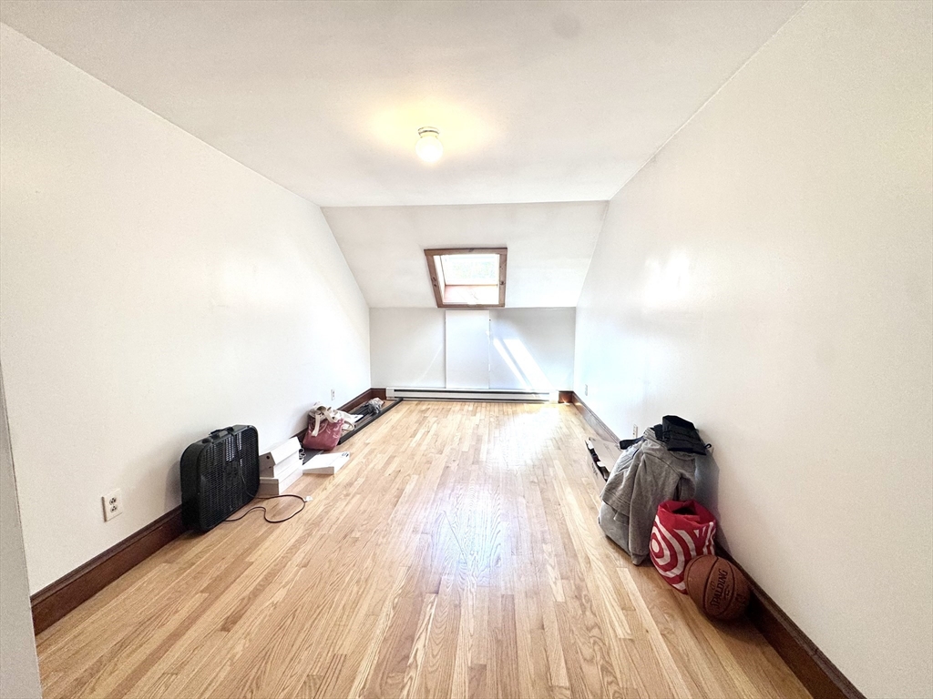 22 Greenough Street, Unit 3 Brookline, MA 02445 - Photo 9 of 14 a view of a bedroom with wooden floor and bed