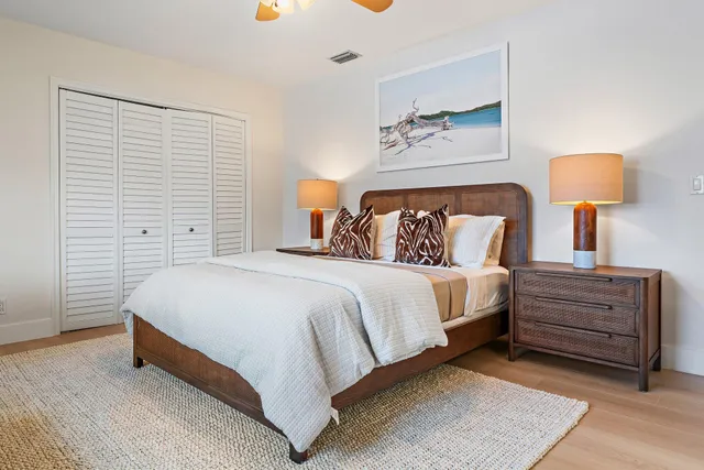 a spacious bedroom with a bed and a lamp on table