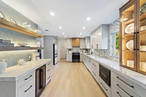 a large kitchen with stainless steel appliances kitchen island a large counter top and a view of living room