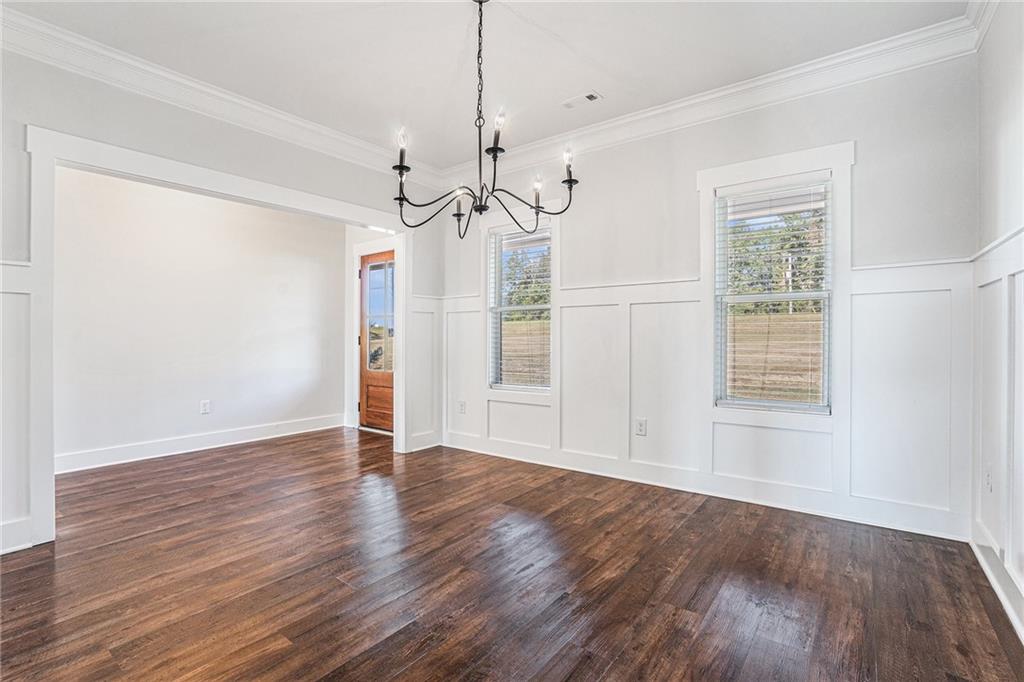 1550 Knox Chapel Road Social Circle, GA 30025 - Photo 11 of 35 a view of an empty room with wooden floor ceiling fan and windows