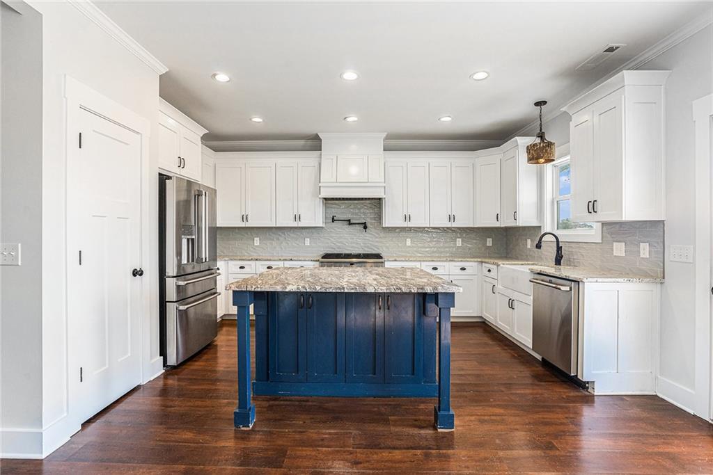 1550 Knox Chapel Road Social Circle, GA 30025 - Photo 13 of 35 a kitchen with kitchen island granite countertop wooden floors stainless steel appliances and cabinets