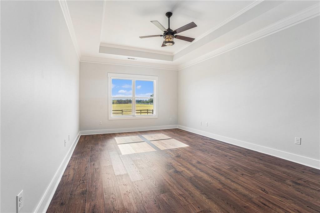 1550 Knox Chapel Road Social Circle, GA 30025 - Photo 21 of 35 an empty room with wooden floor ceiling fan and windows