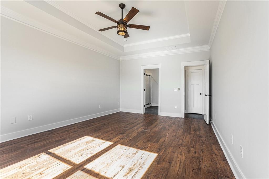 1550 Knox Chapel Road Social Circle, GA 30025 - Photo 22 of 35 an empty room with wooden floor and a ceiling fan