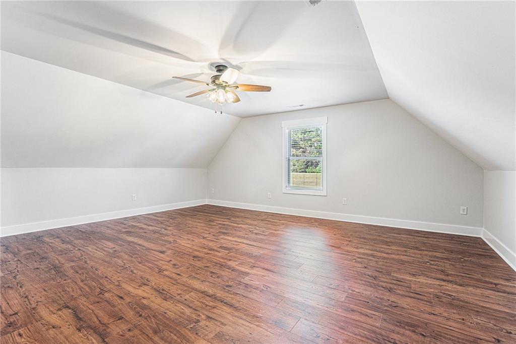 1550 Knox Chapel Road Social Circle, GA 30025 - Photo 32 of 35 an empty room with wooden floor chandelier fan and windows