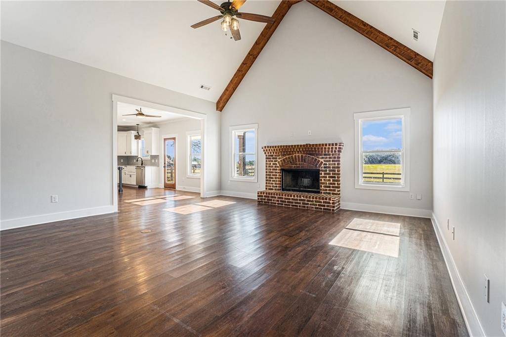 1550 Knox Chapel Road Social Circle, GA 30025 - Photo 7 of 35 an empty room with wooden floor fireplace and windows
