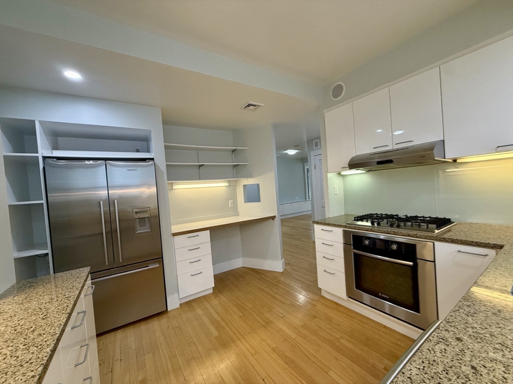 174 Maplewood Street, Unit 174 Watertown, MA 02472 - Photo 12 of 30 a kitchen with stainless steel appliances granite countertop a stove a sink and a refrigerator