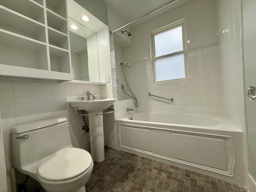 174 Maplewood Street, Unit 174 Watertown, MA 02472 - Photo 18 of 30 a white toilet sitting next to a bath tub