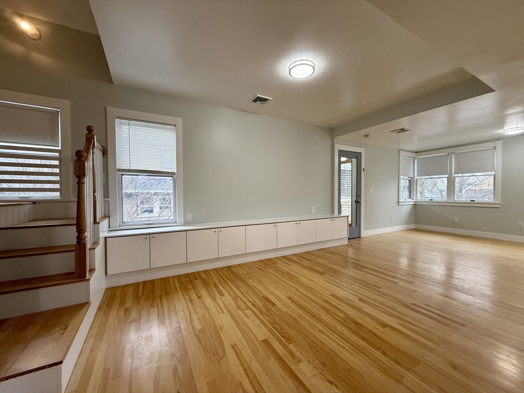 174 Maplewood Street, Unit 174 Watertown, MA 02472 - Photo 3 of 30 a view of empty room with wooden floor and fan