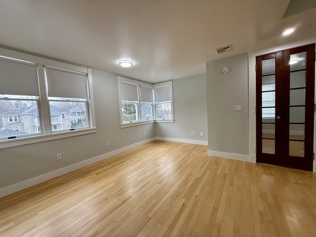 174 Maplewood Street, Unit 174 Watertown, MA 02472 - Photo 7 of 30 wooden floor in an empty room with a window