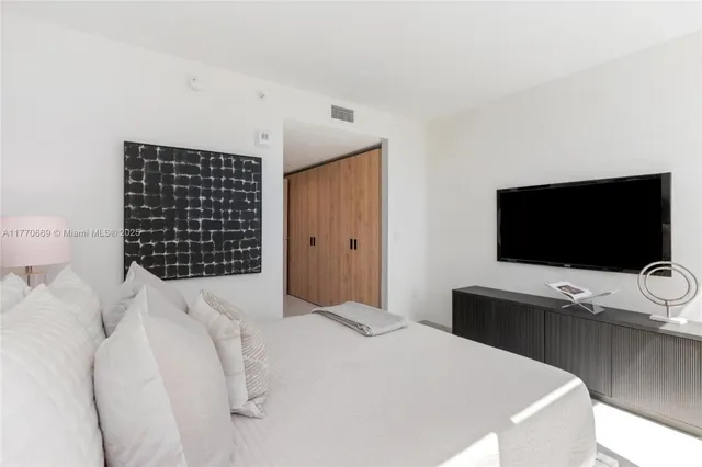 a bedroom with a bed and a large window