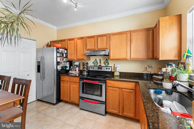 a kitchen with stainless steel appliances granite countertop a refrigerator stove and sink