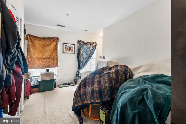 a bedroom with a bed and a flat tv screen on dresser