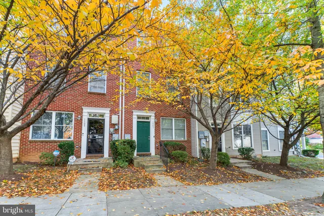 a front view of a house with a tree in front