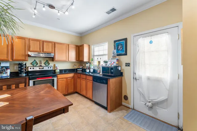 a kitchen with stainless steel appliances granite countertop a refrigerator and a stove top oven