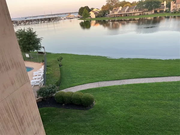 a view of a hallway with wooden floor furniture and windows