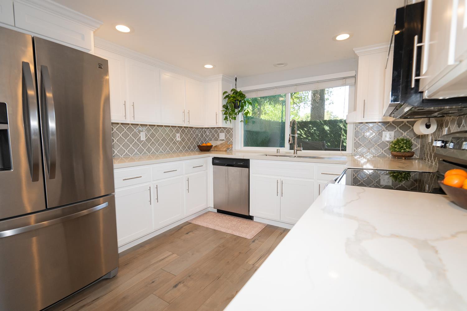 2672 Rio Bravo Circle Sacramento, CA 95826 - Photo 8 of 26 a large kitchen with stainless steel appliances kitchen island granite countertop a refrigerator a sink dishwasher a stove and white cabinets with wooden floor