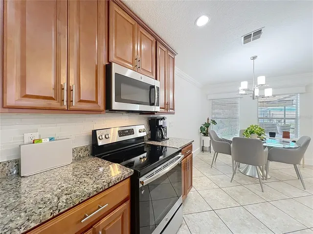 a kitchen with granite countertop a refrigerator stove and microwave
