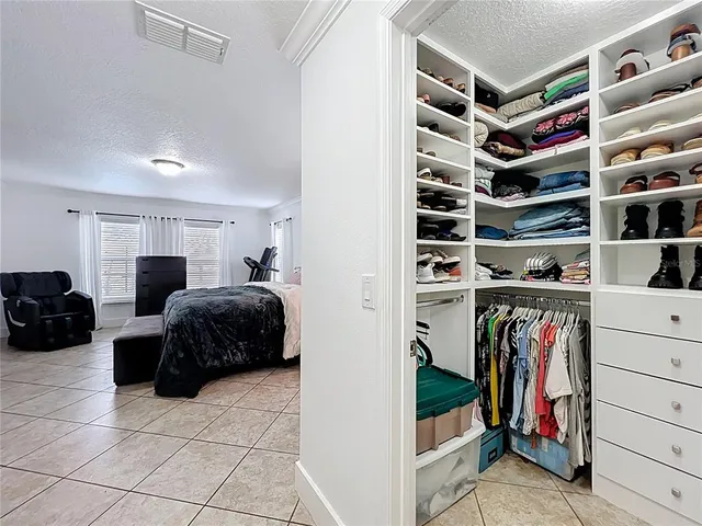 a spacious bedroom with a bed and a cabinets