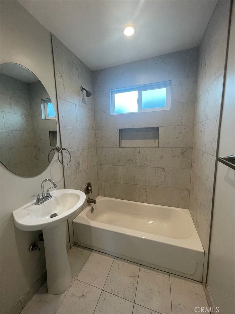 1413 East 53rd Street Los Angeles, CA 90011 - Photo 2 of 11 a bathroom with a sink a bathtub and a mirror