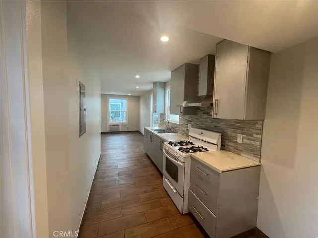 a kitchen with stainless steel appliances granite countertop a stove a sink and a refrigerator