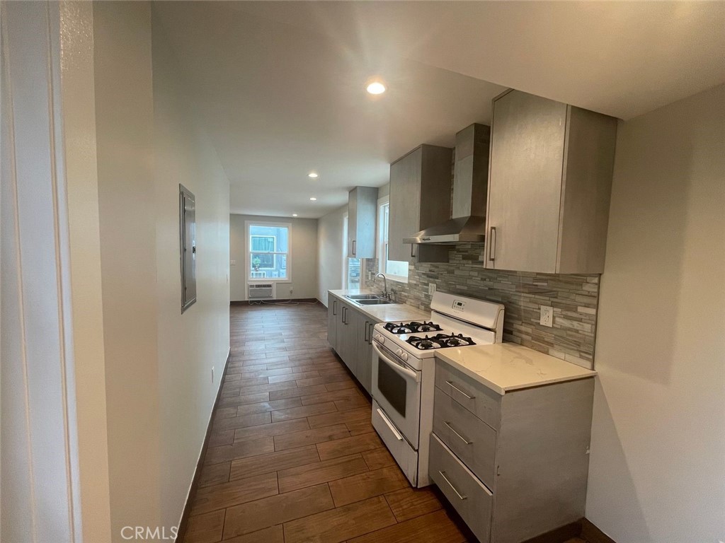 1413 East 53rd Street Los Angeles, CA 90011 - Photo 4 of 11 a kitchen with stainless steel appliances granite countertop a stove a sink and a refrigerator